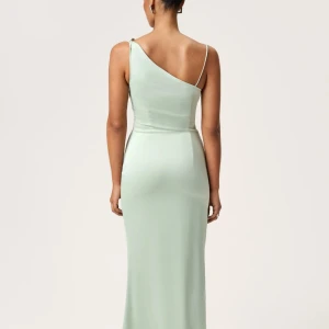 Sage Green Dress från Adoore - Elegant ljusgrön långklänning med oneshoulder-design och smal passform. Klänningen har en axelbandslös sida och en smal axelrem. Klänningen är från Adoore i färgen Sage Green, storlek 32, jag är egentligen en S/34 men den passar bra ändå. Säljer min fina balklänning då jag hittat en annan och jag ej kunde lämna tillbaka den pga att det gick mer än 30 dagar. Helt oanvänd bara testad, lappar fins var. Tveka inte att höra av dig vid frågor och funderingar. Pris kan diskuteras vid snabb affär!