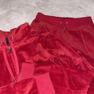 Röd velourtröja från Juicy Couture - Jag har ett par juicy couture för salu Det är inte mina men det är min dotters Hon vill inte ha dem längre jag köpte dem till henne för ungefär 6 månader sen Storlek XS och röd färg det kommer med en kofta och byxor pris kan diskuteras och kan skicka mer bilder😀