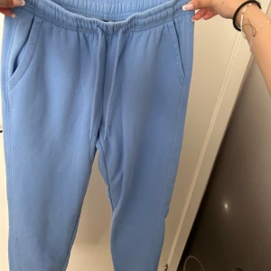 Ljusblå mjukisbyxor med resårmidja - Säljer ett par ljusblå mjukisbyxor med resår i midjan och sidofickor. Perfekta för en avslappnad stil och superbekväma att ha på sig. Byxorna har en normal passform och är gjorda i mjukt material.