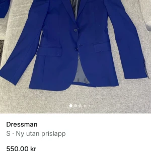 Blå kostym från Dressmann - Säljer en stilren blå kostym från Dressmann i slim fit-modell. Kostymen består av en kavaj med två knappar och matchande byxor. Perfekt för bal eller festliga tillfällen. Materialet känns mjukt och följsamt.