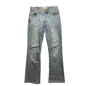 Crocker jeans - Säljer ett par klassiska blå jeans från Crocker med fem fickor och bootcut passform. Jeansen har normal midja och är tillverkade i slitstarkt denim. Perfekta för dig som gillar en tidlös stil med lite vidare ben. Anledningen till det låga priset är för att det finns ett hål längst ner på bakre sidan på vänstra benet.