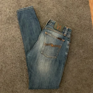 Nudie jeans - Säljer ett par klassiska blå jeans från Nudie Jeans i modellen skinny lin, med strlk W28 L32. Skick 8/10 nästan helt nya inga slitage. Pris är inte hugget i sten, meddela mig vid frågor eller funderingar.