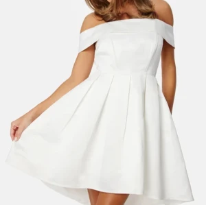 Studentklänning - Vit offshoulder klänning - Superfin vit offshoulder klänning från Bubbleroom med veckad kjol och axelbandslös design. Klänningen har en elegant och stilren look med markerad midja och lätt utsvängd kjol. Perfekt för studenten! Oanvänd. Ordninarie pris 899kr