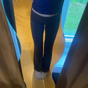 Mörk grå yoga pants från Gina tricot - Säljer ett par mörk grå  med bootcut och låg midja. Yoga pants somhar en tight passform upptill och blir vidare nedtill. Perfekta för en avslappnad och trendig stil. Bra skick 