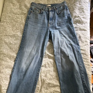Blå jeansbyxor från Gina Tricot - Säljer dessa snygga men knappt använda jeans från Gina Tricot!! Vida ben och hög midja, möjligtvis något stora i storlek, långa i benen och passar mig som är 179. Inga tecken på användning. Hör av dig om du har frågor eller kom med prisförslag💕
