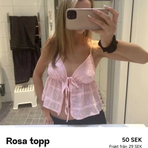 Rosa broderad linnetopp med knyt - Söt rosa linnetopp med broderade detaljer och knyt framtill. Toppen är ärmlös med tunna axelband och har en luftig, croppad passform. Perfekt för varma dagar och somrig stil. Köpte denna ifrån plick!