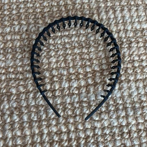 Svart diadem - Säljer ett svart trändigt diadem. Både snygg och användbart för att hålla håret borta från ansiktet. Säljer pga att den inte kommer till användning. Skriv om fler bilder💕