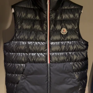Svart dunväst från Moncler - Snygg  marinblå moncler väst. Passar för dig som är runt 160-170cm lång. Fritt fram att ställa frågor vid funderingar eller annat.