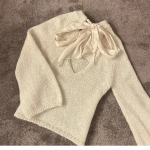 Glitter stickad  tröja med rosett - Superfin glitter stickad tröja med v-ringning och stor rosett i sidenband bak i nacken. Super fin att bara ha över sig på sommaren😍