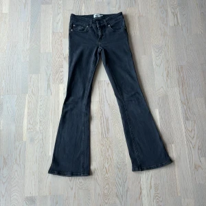 Bootcut jeans  - Snygga svarta bootcut jeans från lager 157 i storlek XXS short. Modellen är low boot med låg midja. Jeansen har en mörkgrå färg och är tillverkade i ett stretchigt bomullsmaterial för skön passform. Mycket använda men i fint skick! Nypris 400kr.