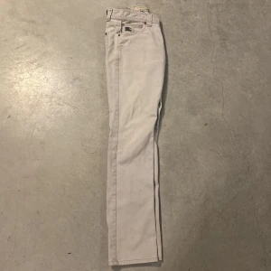 Ljusgrå jeans från Burberry London - Snygga ljusgrå jeans från Burberry London, tillverkade i Italien. Klassisk femficksmodell med broderad Burberry-logga på myntfickan. Raka ben och normal passform, perfekta för en clean och stilren look.