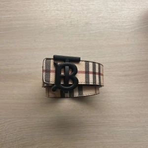Burberry tvåsidigt bälte - Snyggt vändbart Burberry bälte med klassiskt mönster. Kan justeras enkelt så att man kan ha den på den sida man vill. Har haft bältet i ca 2 år men det är fortfarande i mycket bra skick. Har kvitto kvar dessutom!👍
