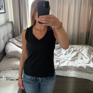 Svart linne med breda axelband - Säljer denna skit snygg topp som inte kommer till någon användning. Super snygg att ha nu till sommaren. Storlek L men passar även någon som bär S/M. Skriv vid frågor och funderingar🥰