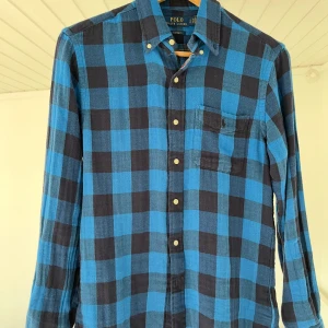 Blårutig skjorta från Polo Ralph Lauren -  blårutig skjorta från Polo Ralph Lauren med klassisk krage, bröstficka och knappar framtill