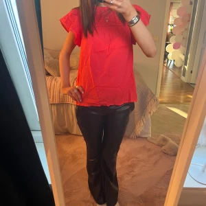 Blus  - Superfin röd blus från Saint Tropez i storlek XS. Blusen har korta volangärmar och ett sött mönster upptill som ger en fin och trendig look. Tillverkad i tunn bomull, perfekt för varmare dagar. Lös passform och rund halsringning. Med följer extra knapp!!!💝💝💝