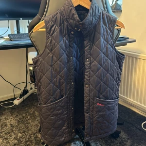 Barbour Quilted Vest  - Säljer en quiltad svart dunväst från Barbour i storlek XXL i Kids vilket motsvarar XS/S, jag är själv en S och den sitter perfekt på mig. Använd ett fåtal ggr. 