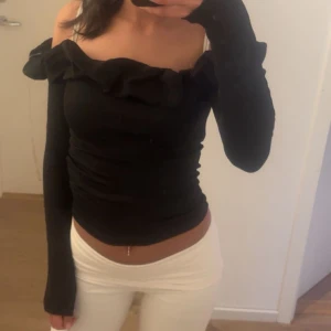 Svart offshoulder topp med volang - Snygg svart offshoulder topp med långa ärmar och volang längs urringningen. Har bara använt den typ 2 gånger 💗