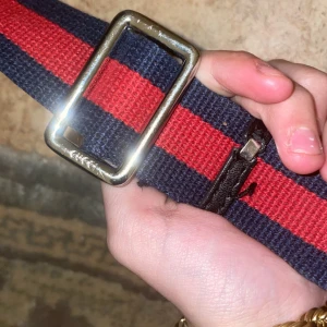 Gucci bag - Snyggt axelväska från Gucci med klassiskt randigt mönster i rött och mörkblått. . Perfekt accessoar för att lyfta din outfit med en lyxig touch, med fler funderingar eller frågor så är det att bara skriva. Använd max 5 gånger.