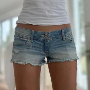 Lågmidjade jeansshorts Hollister - Ett par ljusblå Hollister jeansshorts i storlek W26 (S). Rakt över midjemått: 38. Längd: 17cm. Gren: 15cm. OBS! Jag skickar dem allra sista paketen den 13 juni, köp efter den 13 juni skickas som tidigast den 22 juni. D4
