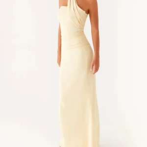 Champagnefärgad långklänning med oneshoulder - Supersnygg långklänning i champagnefärg med oneshoulder och draperad detalj över axeln. Klänningen har figurnära passform och är tillverkad i ett mjukt, stretchigt material som ger en lyxig känsla. Perfekt för dig som vill sticka ut med en elegant och modern look. Endast använd en gång. 