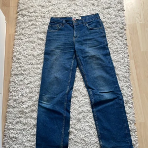 Levi's Loose Taper jeans blå - Säljer ett par klassiska blå Levi's Loose Taper jeans, jeansen har en loose passform upptill och smalnar av nedtill för en modern look. Tillverkade i slitstarkt denim med ikonisk läderpatch bak. Storlek 176 