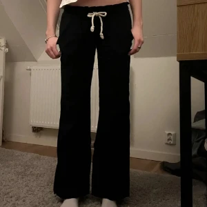 Svarta/marinblå linnebyxor med snörning - Snygga svarta linnebyxor med vit snörning i midjan. Från Roxy!