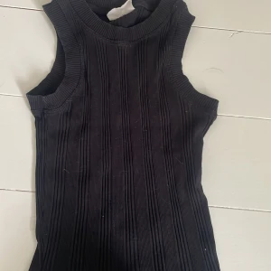 Svart ribbad topp från Gina tricot - Knappt använd linne eller väst från Gina tricot i mycket bra skick. Fint ribbat mönster och mjukt material. Från basically basics kollektion i storlek xxs men stretchigt tyg så passar även lite större storlekar. 