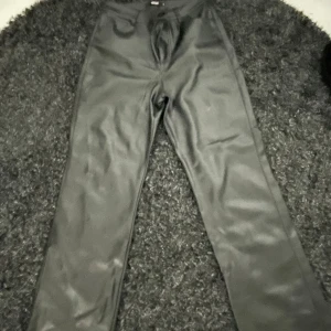 Svarta byxor från BikBok - Snygga svarta skinnbyxor från BikBok. Byxorna har en hög midja och raka ben.