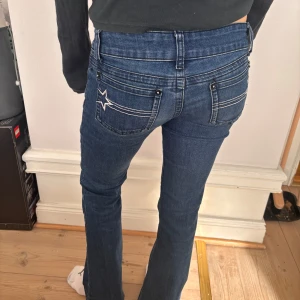 Lågmidjade Blå jeans - Snygga blå jeans med en cool stjärndetalj på bakfickorna. De har en låg midja och är bootcut. 