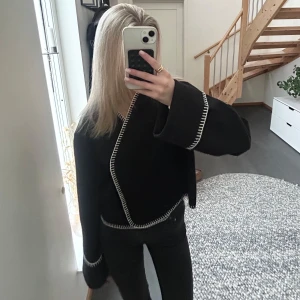 Svart ”kappa”  med vita sömmar  - Säljer denna jättesnygga svarta ”kappan” med vita sömmar. Perfekta jackan nu till våren! 