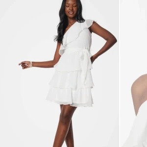 Vit omlottklänning med volanger - Perfekt studentklänning! I storlek 38 passar både en S och M. Aldrig använd prislappen finns kvar