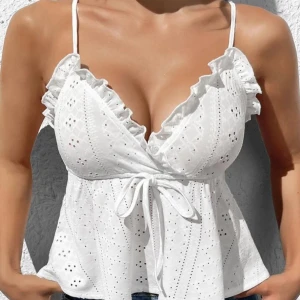 Linne med volanger - En söt vit blus med smala axelband och volangdetaljer. Stl. M, men är mer som en XS/S. Endast testad. Nypris 89kr.