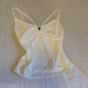 Vit linnetopp från BikBok - Säljer en stilren vit linnetopp från BikBok med smala axelband och en elegant skärning vid bysten. Perfekt för varma dagar eller som ett lager under en kavaj. Toppen har en mjuk och bekväm passform, aldrig använt 🤍