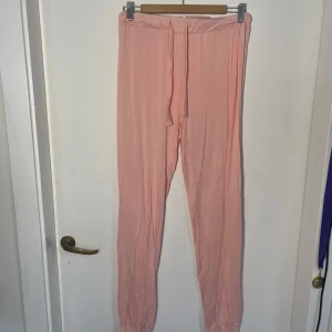 Rosa pyjamasbyxor  - Säljer ett par bekväma rosa pyjamasbyxor med resår i midjan. Byxorna är tillverkade av en mjuk blandning av viskos och elastan, vilket ger dem en skön stretch. Perfekta för en avslappnad dag hemma. Lite noppror.