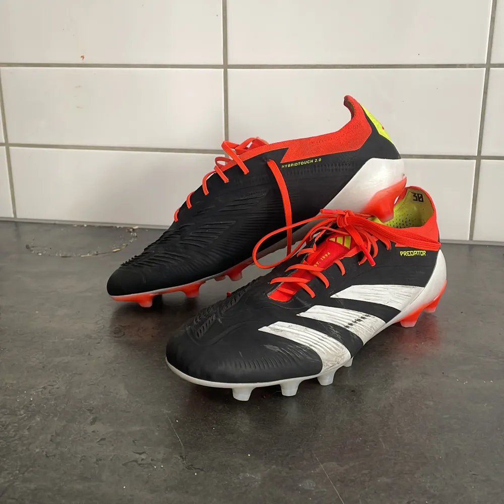 Säljer ett par Adidas Predator fotbollsskor i svart och röd med vita detaljer. Skorna är knappt använda och har fortfarande väldigt mycket användning kvar. Säljer dom då jag inte har någon användning för de.. Kengät.