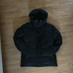 Svart dunjacka  - Säljer en svart dunjacka från Icepeak. Jackan är väldigt varm och prefekt för kyliga dagar eller storm. Väldigt mysig om du är ute efter en varm och bekväm jacka. Jackan är använd fåtal gånger och inte sliten på något sett. Ny pris 1700. Skick 10/10