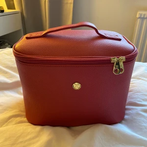 Don Donna necessär  - Snygg rosa necessär med leopardmönstrad på insidan, och praktisk dragkedja. Den har flera fack och en krok för upphängning, perfekt för att organisera dina saker. Stilren design med ett handtag för enkel transport. Det tillkommer även en mindre genomskinlig necessär 🩷