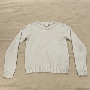 Vit stickad tröja från Vila - Jättefin stickad tröja från Vila. Tröjan har en rund halsringning och långa ärmar med ribbade muddar vid ärmslut och nederkant. Perfekt till alla stilar!!