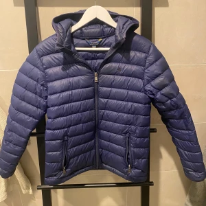 Ralph Lauren - En fin lätt viktaduns Ralph Lauren jacka i mörk blå färg. Den är i väldigt fint skick förutom en liten reva på höger arm som går att fixa 8/10 🔥