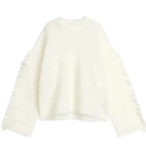 Superfin vit stickad tröja ifrån arket! - Säljer nu min jättefina stickade tröja med volanger då den inte kommer till användning längre!! Tröjan var krympts i tvätten. Passar mig som brukar ha storlek S💞💞