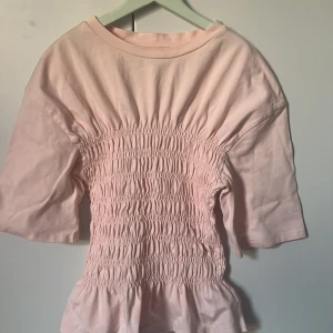 Ljusrosa topp från & Other Stories - Säljer en söt ljusrosa topp från & Other Stories med smockdetaljer som ger en fin passform. Den är slutsåld , men är väldigt populär💖💖🌸🌸