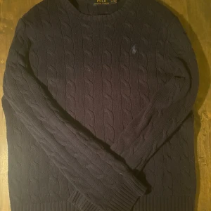Kabel stickad Ralph lauren  - Kabelstickad Ralph lauren, mörkblå inga tydliga defekter, bra skick, hus med djur. 🙌