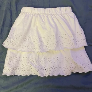 Vit kjol från Zara - Söt vit kjol från Zara med broderade detaljer och volanger. Elastisk midja. Superfin kjol till sommaren. Använt fåtal ggr