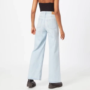 Ljusblå vida jeans - Fina ljusblåa jeans från Weekday. Storlek W32/L30. Sitter som en L. Högmidjade och vida ben. En fläck på höger ben framsida, har inte prövat att använda fläckborttagning men det fungerar säkert. (OBS bilderna från hemsidan visar en ljusare färg)