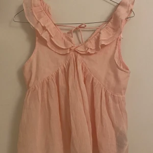 Rosa ärmlös topp - Söt rosa ärmlös topp från Gina Tricot med volangdetaljer runt halsen och knytning i nacken. Perfekt för sommaren !                                                          Aldrig användt 💗