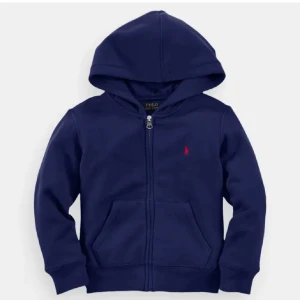 Mörkblå hoodie från Ralph Lauren - Säljer en snygg mörkblå hoodie från Ralph Lauren med dragkedja och huva. Är näste helt ny är 10/10 i skick. Ny pris är 1 600kr 