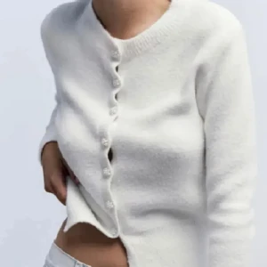 Vit kofta med pärlknappar - Säljer en supermjuk och stilren vit stickad kofta med långa ärmar. Koftan har fina pärlknappar framtill och en klassisk rund halsringning. Den är från Zara men är slutsåld hela tiden