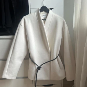 Vit omlottjacka/kappa  - Jacka från Kappahl, XS. (Passar S/M)  Skriv privat för foton från hemsidan samt en närbild på lite noppor vid vänster ficka. Använd 5-8 gånger någonstans.   Denna finns att köpa på Kappahl för 999kr, dock