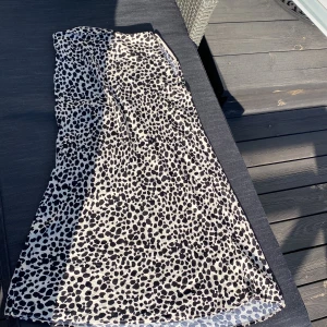 Leopardmönstrad maxikjol från About You - Snygg leopardmönstrad kjol från About You i storlek 34. Perfekt för att sticka ut med sitt djärva mönster. Kjolen är i ett ljuvligt sidenliknande material som ger ett snyggt fall. I princip oanvänd. Blixtlås i midjan.