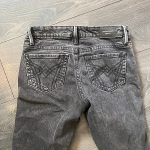 Grå jeans från Perfect Jeans - Snygga grå jeans från Perfect Jeans med klassisk femficksdesign och broderade bakfickor. De har en rak passform och är perfekta för en avslappnad stil. Passar bra till både sneakers och kängor.